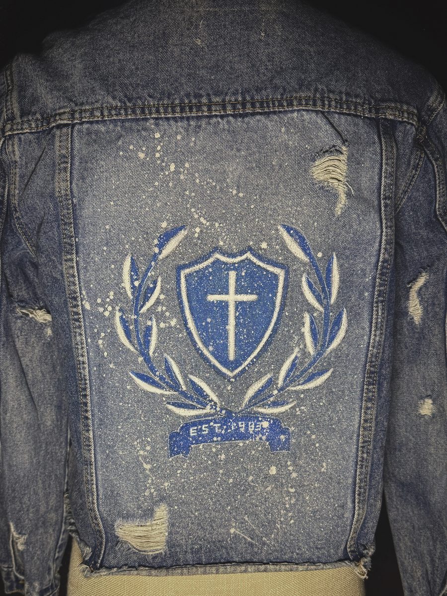 Hand-painted cross and laurel crest on distressed denim