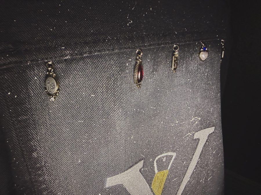 Vintage gemstone charms across black denim